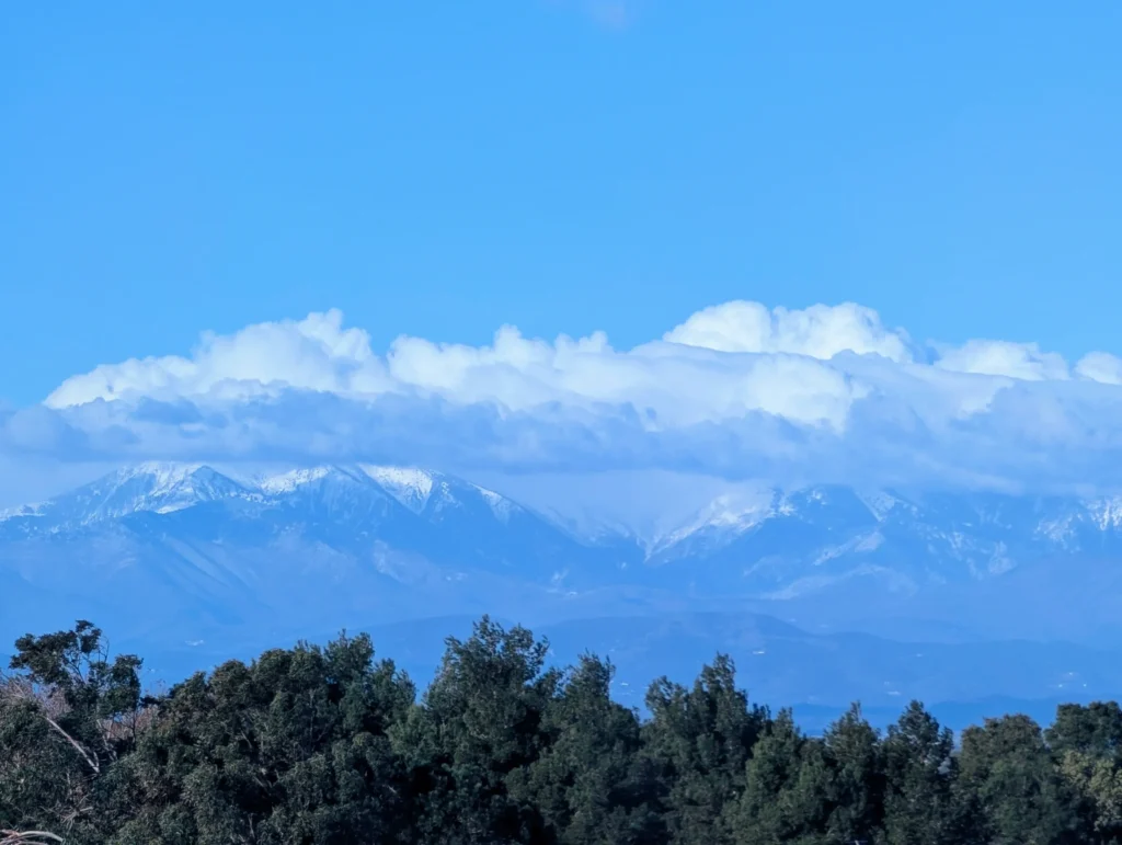 Snow-capped mountains under clouds and blue sky