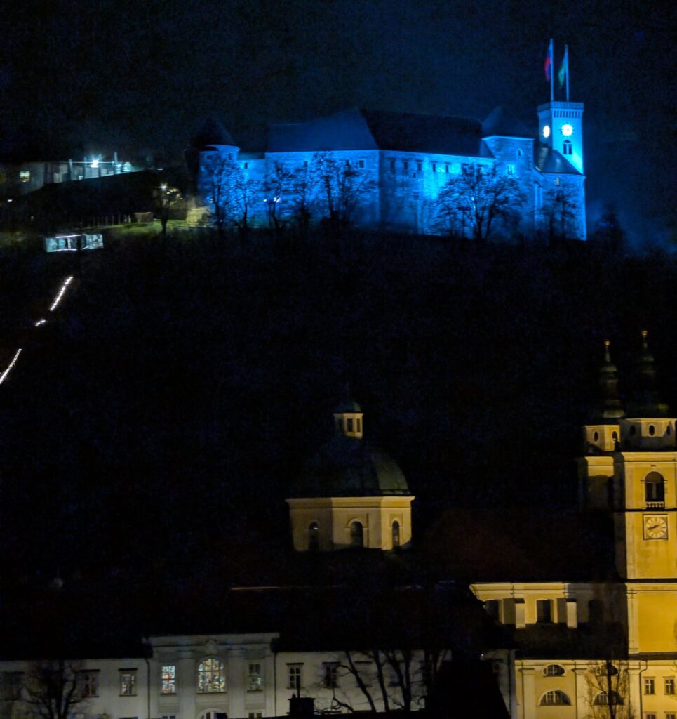 Blue-lit castle and clock tower at night