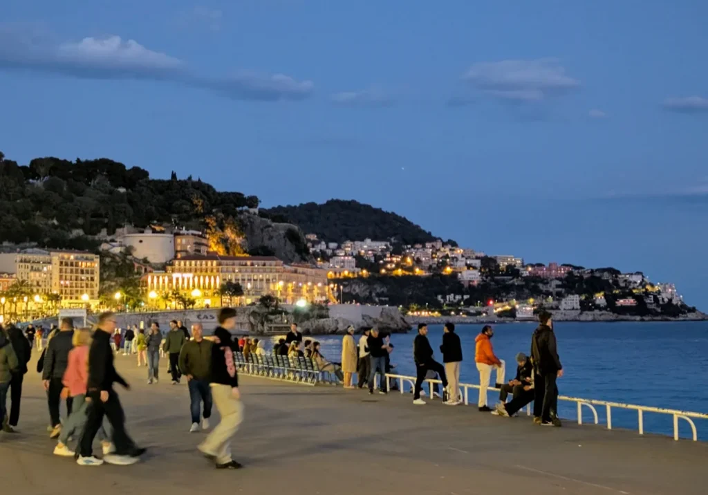 People strolling along seaside promenade at dusk