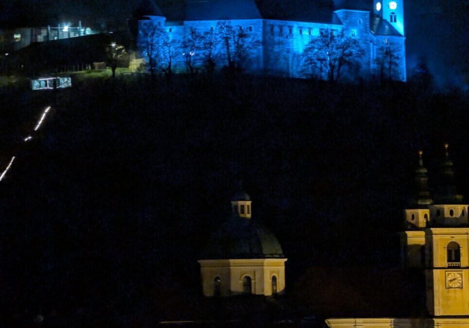 Blue-lit castle and clock tower at night